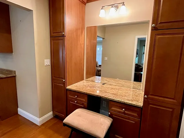 Granite Desk/Vanity with maple cabinetry and storage towers on both sides.