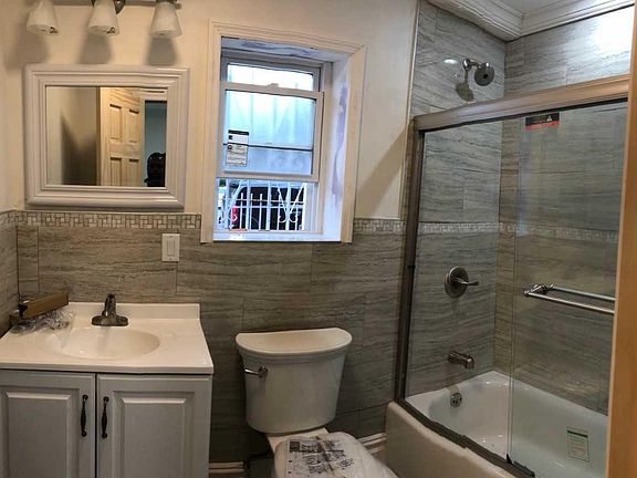 Newly renovated bathroom with new shower doors, tiles, toile
