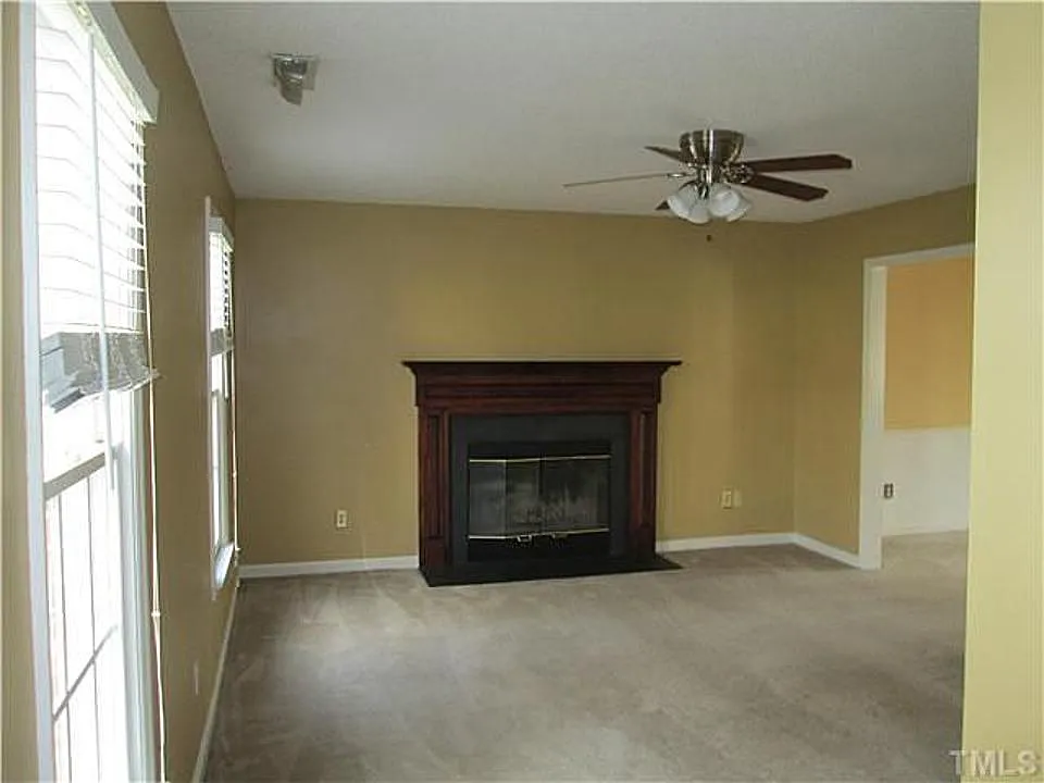 Living room with wood-burning fireplace and ceiling fan - 114 Cibola Dr