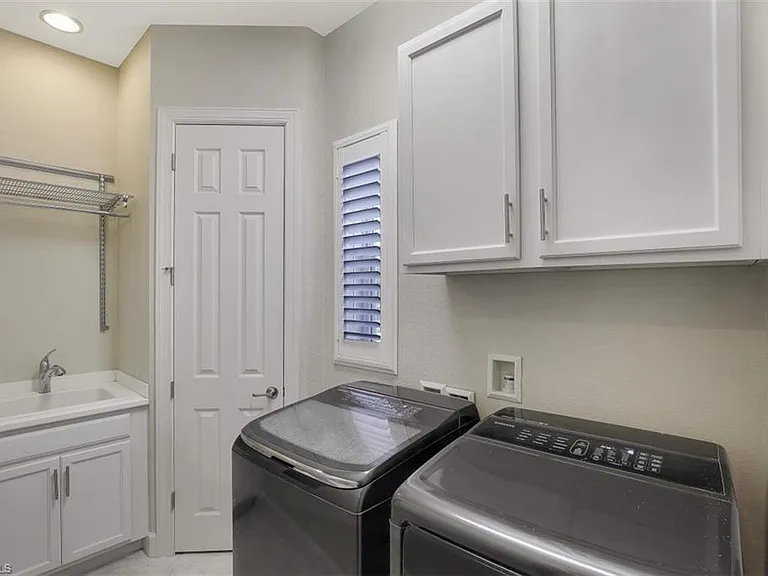 Laundry room, washer, dryer, sink, hanging rack.