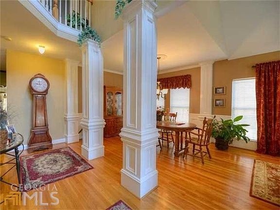 Grand 2 story entrance foyer features gleaming hardwood floors, columns into the dining room & livin