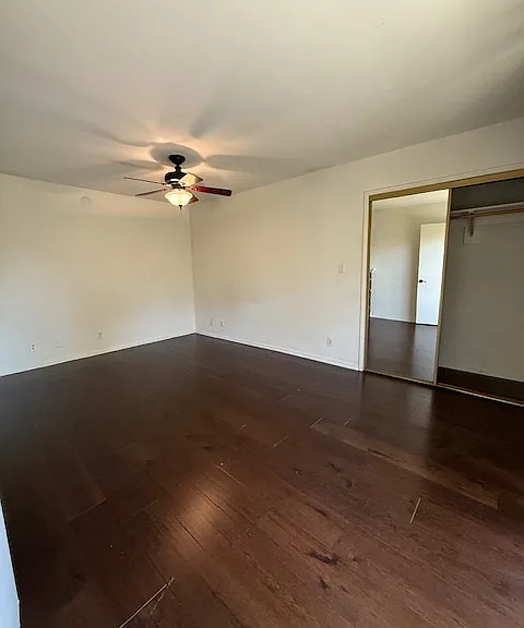 Opposite view of front bedroom with ceiling fan/light & mirrored closet
