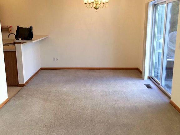 Living room/dining room opening into kitchen and patio