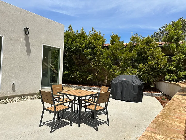 Outdoor patio with gas gill, dining table and chairs