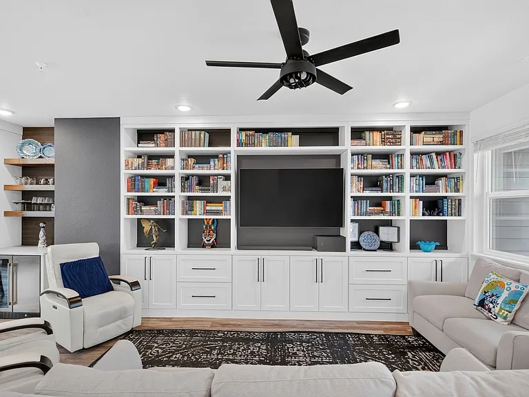 Living room with built-in bookcases, storage, and entertainment center