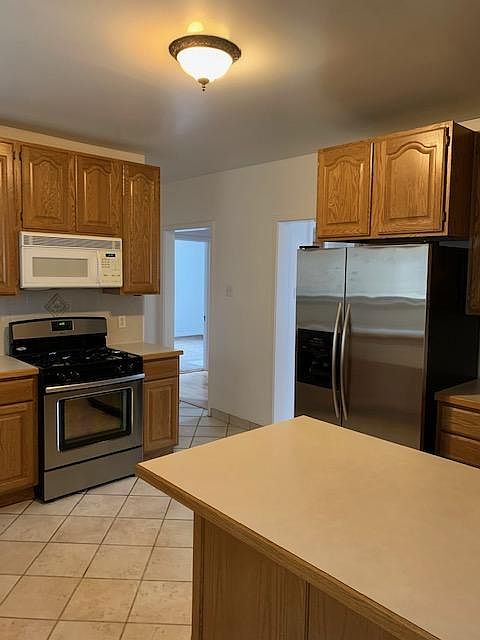 Kitchen With Island And Stainless Appliances
