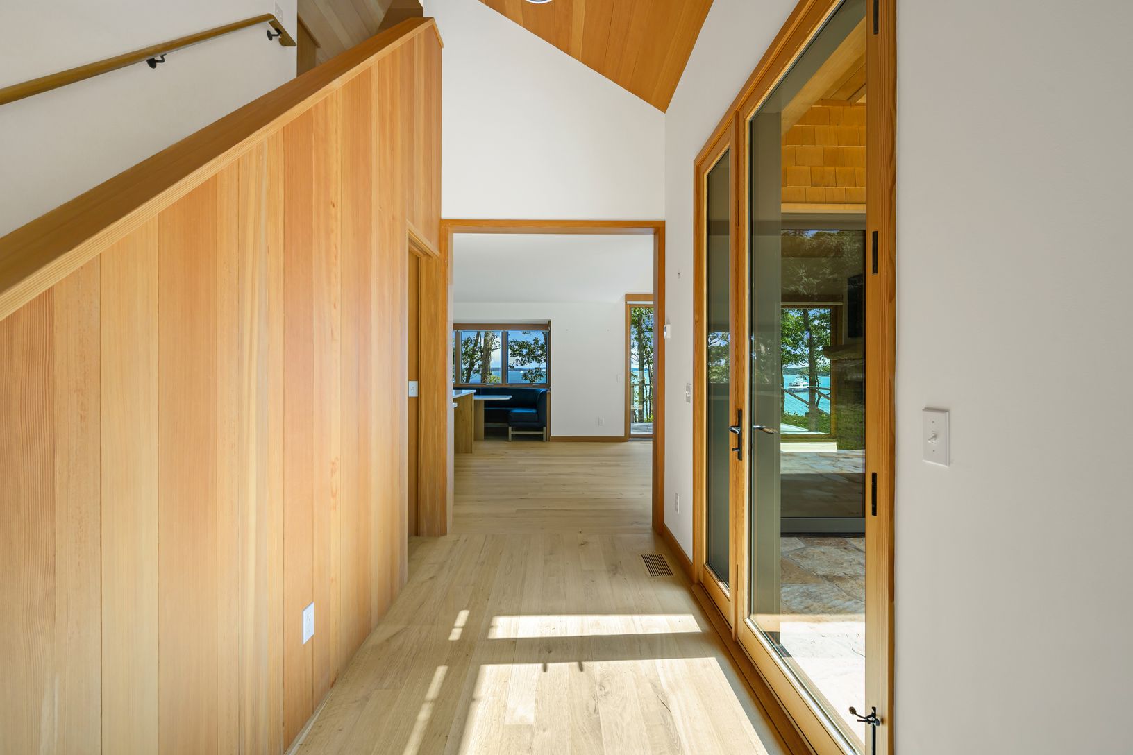  Large glass door at entry. Wood staircase wall with elevated ceilings.