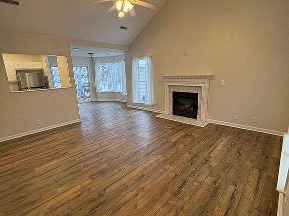 Large living room with vaulted ceilings and fireplace with bar looking into kitchen!