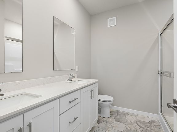 The master bathroom has a dual sink vanity and a step in shower.