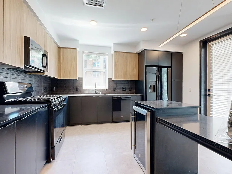 Apartment Kitchen with large counter tops and Wood-Style Flooring.