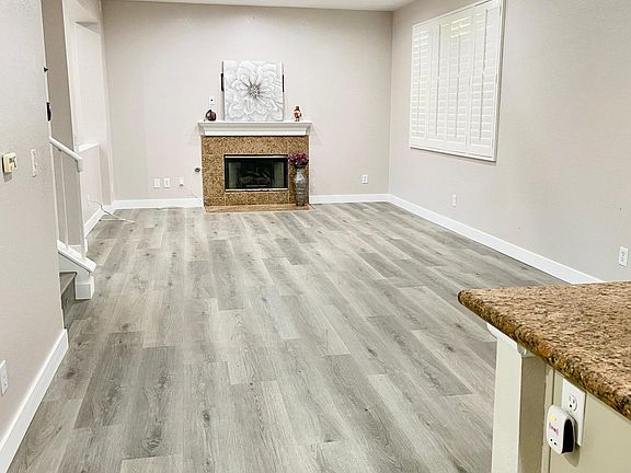 Open space of dining room and family room. TV wall mount is already installed on top of the fireplace.