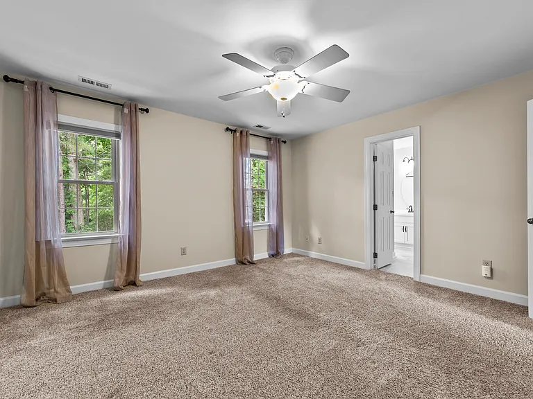 Primary bedroom offers wooded views and direct access to the en-suite bath.