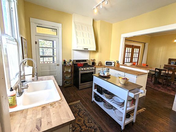 Kitchen has refrigerator, range, microwave, butcher block counters, and center island. Access porch from kitchen