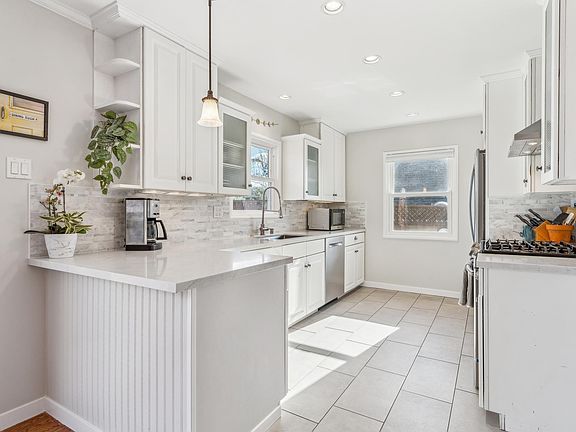 chef's kitchen with radient heated tile flooring, recessed lighting and newer stainless appliances