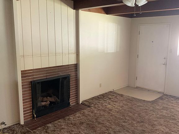 View from dining room into front door entry of living room. Updating to wood floors and new ceiling and wall paint color.