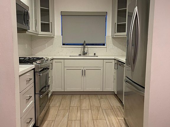 New kitchen with quartz counters, custom cabinets, stainless steel appliances