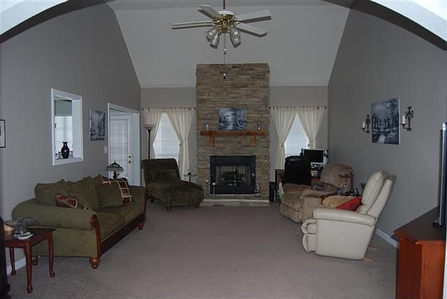 Large family room with stacked stone gas log fireplace.