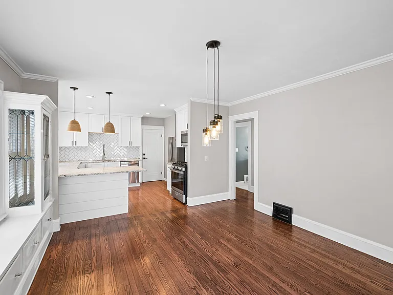 This is the view coming from the far end of the dining room looking into the kitchen. You can also see the hallway that leads to two bedrooms and a bathroom.