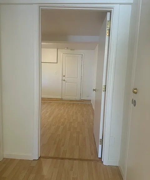 looking from hallway into bedroom and back door. The back door leads to private back patio area and laundry facility