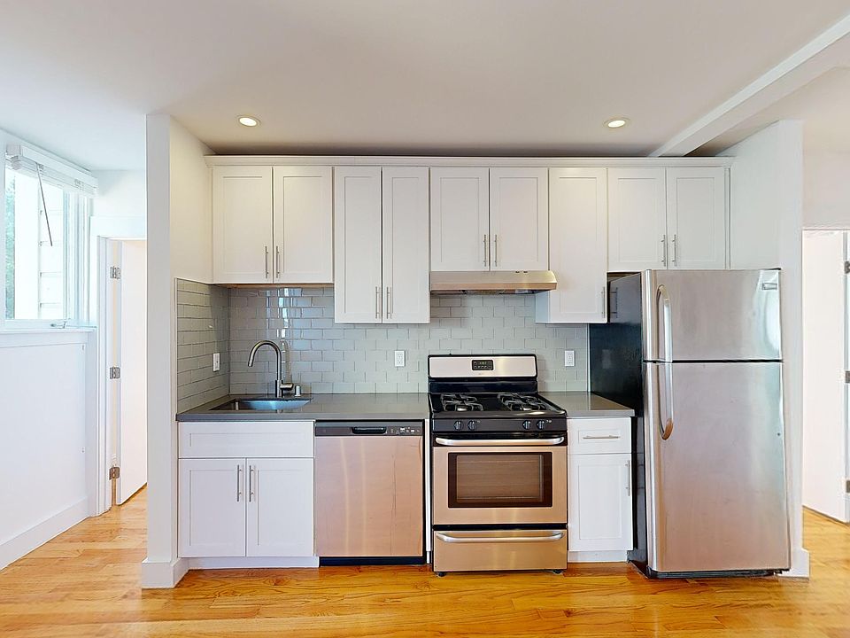 Kitchen with cabinets, refrigerator, stove, range hood, and sink
