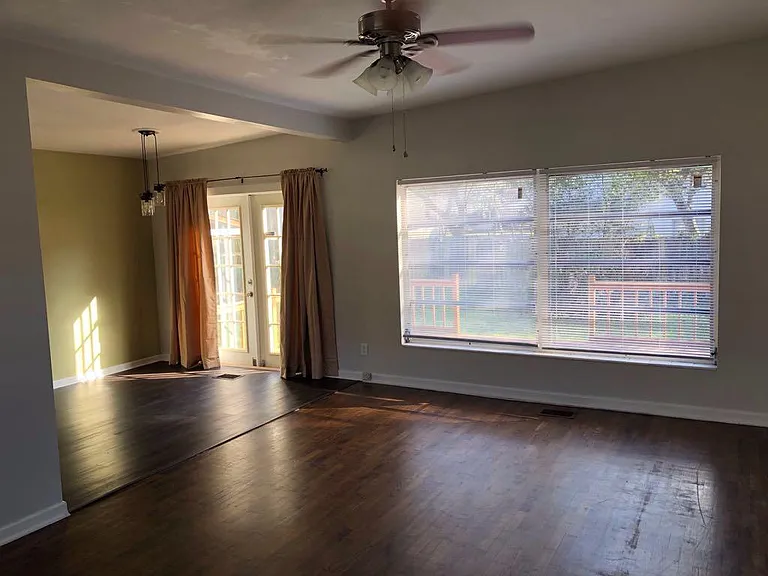 This view is from the front door area looking towards living room and the dining room to the left. French doors lead to the wood deck and fenced backyard. Big windows! Kitchen is just out of view on the left.