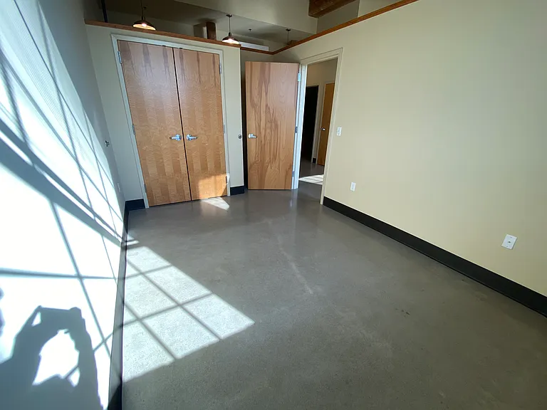 Bedroom interior, with clothing closet and space behind the door for a dresser or shelves.