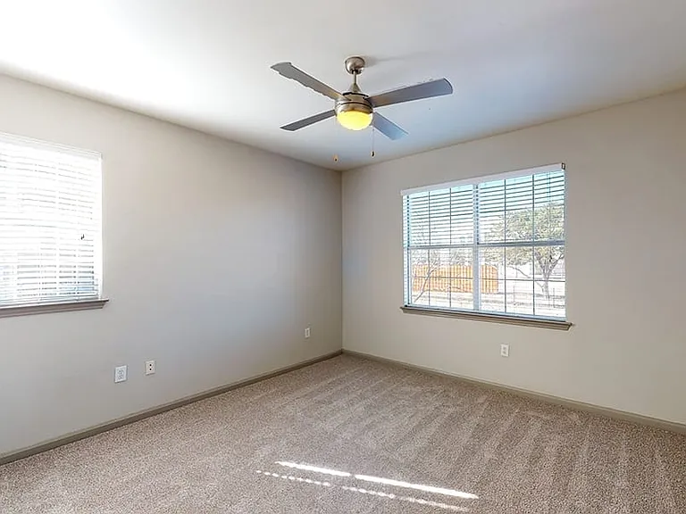 Spacious apartment bedroom with plush carpet flooring
