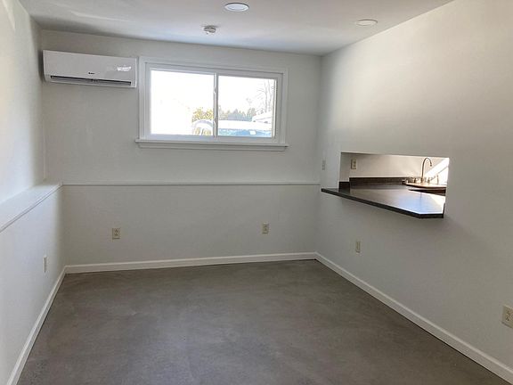 Living room with passthrough to kitchen and counter ledge.