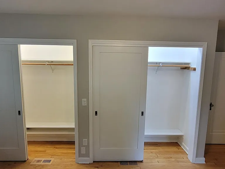 Master bedroom. Large "his and hers" closets with bright lights, Hooks, clothing bar, upper shelf, and shoe shelving.