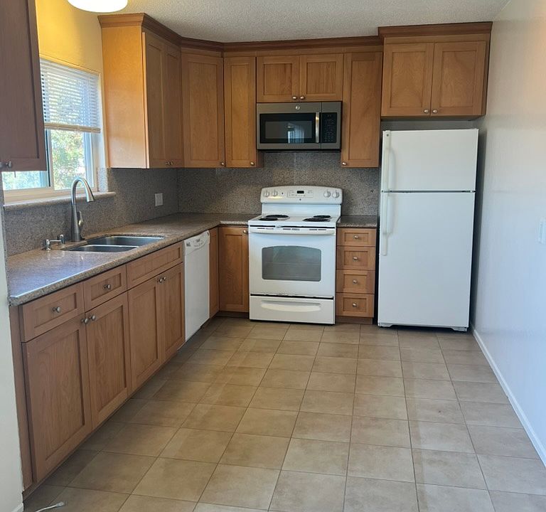 Large kitchen with microwave, stove top oven, refrigerator and dishwasher.