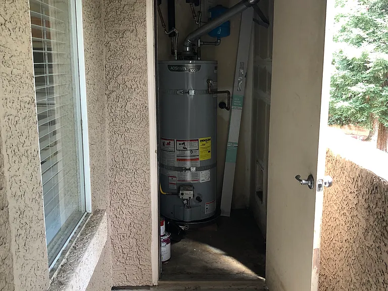 Newer water heater and storage closet off patio.