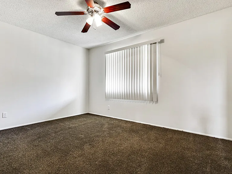Bedroom with ceiling fan, carpeted flooring, vertical window coverings