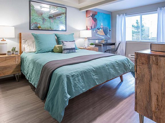 Spacious apartment bedroom with wood floors.