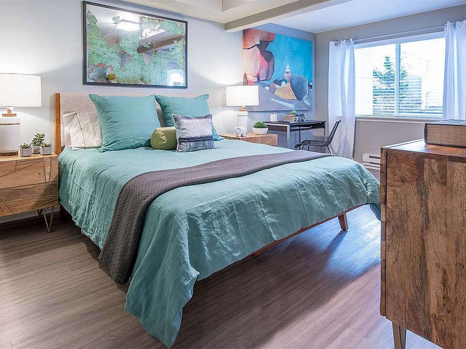 Spacious apartment bedroom with wood floors.