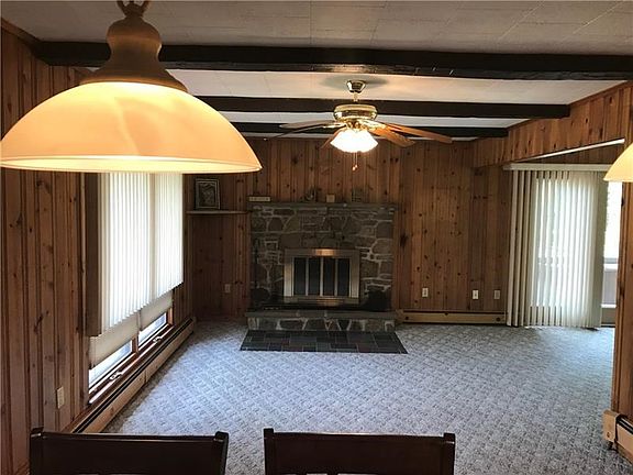 Knotty pine paneling and cozy wall-to-wall carpet make the living room comfortable.  Wood burning fire place and quick access to