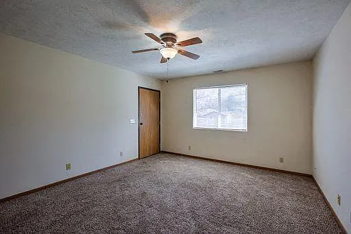 Living room with carpet and ceiling fan at Gretna Oaks.