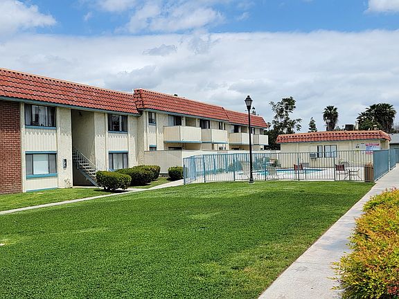 Gated swimming pool and grassy courtyard at Magnolia Apartments in Riverside, California.