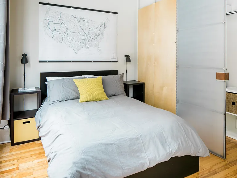 Bedroom includes designer furniture with under-bed storage, as well as custom designed feature closet door