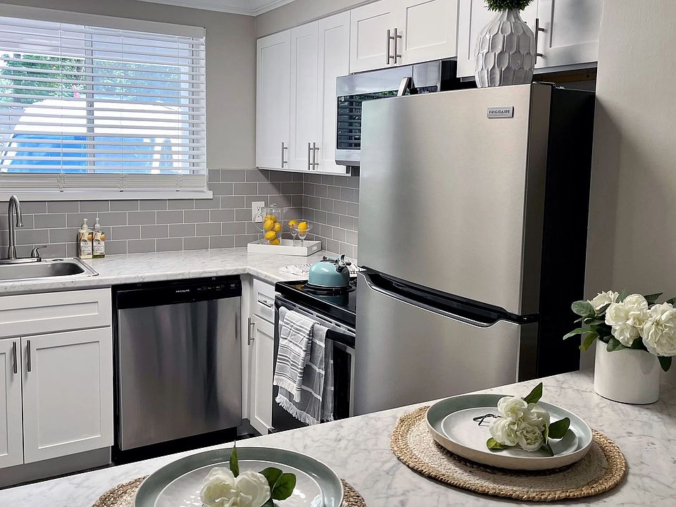 Indulge in the allure of elevated modern kitchen offerings adorned with luxurious white marble-inspired countertops, a sophisticated grey backsplash, and sleek white shaker cabinets.