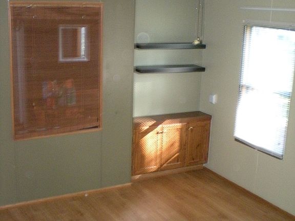 Living room with nook from front entry, new floors, paint, and ceiling fan