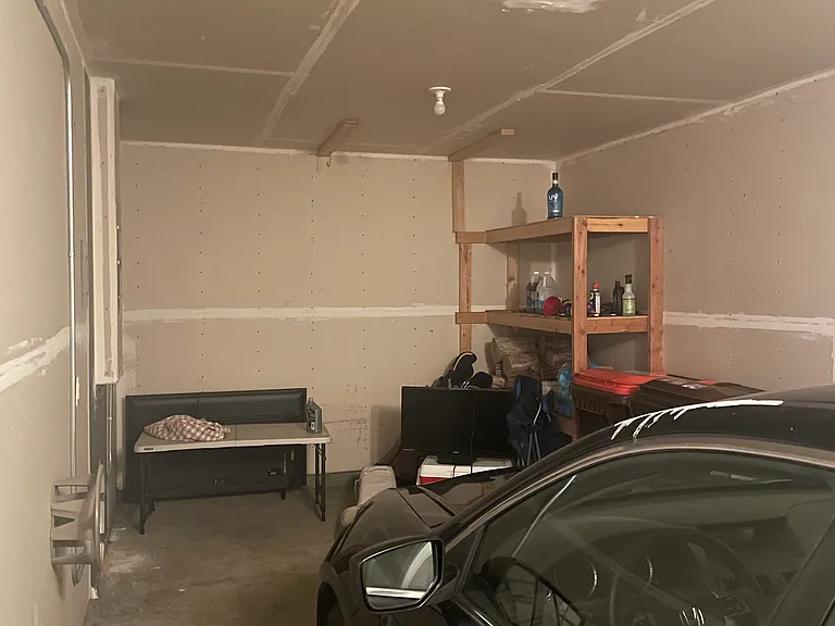 Garage with storage room in front of car