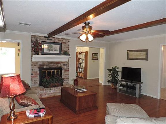 Gas log fireplace centrally located, separating the sunroom from the family room.