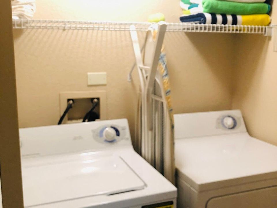 Washer and dryer with iron and ironing board.