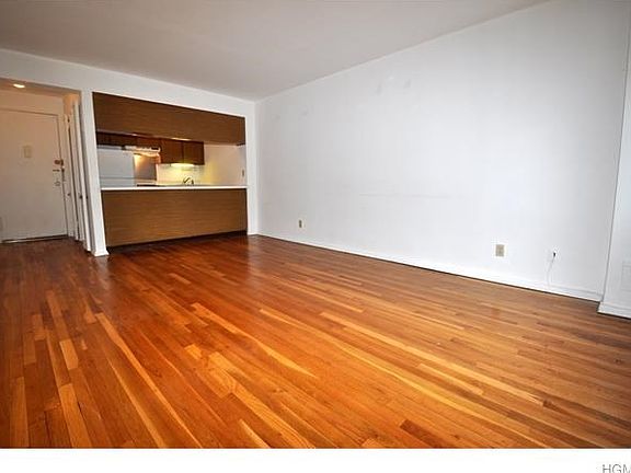 Living Room has refinished hardwood floors and an opening to the kitchen