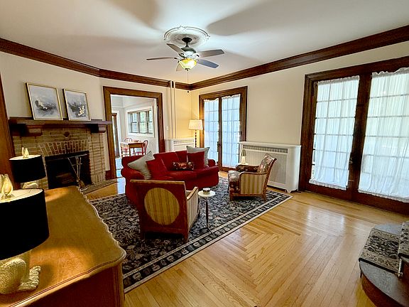 Large living area is flooded with light and features a working fireplace, flat screen TV and high end antique furnishings.