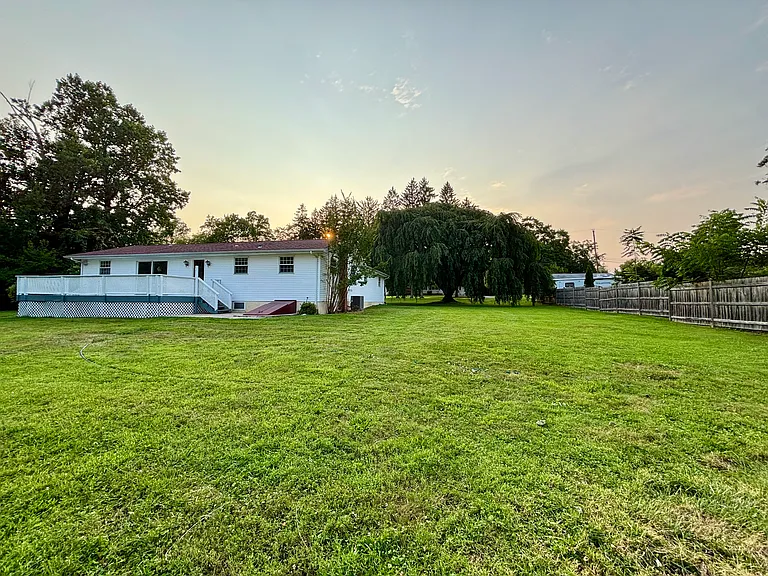 Enjoy nearly an acre of open outdoor space featuring a spacious backyard, mature trees, and an expansive deck_perfect for entertaining, recreation, or simply relaxing in a peaceful setting.