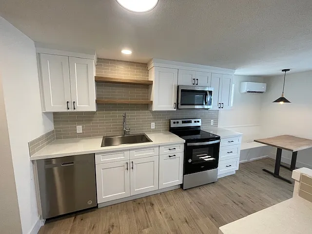Extra Large kitchen-solid quartz counters, full height subway tile backsplash with floating shelves. New stainless deep basin sink and commercial style stainless pull out faucet. New stainless range and microwave - 122 E Wapato Way