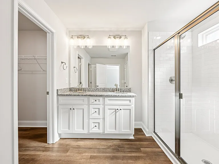 Primary bathroom with double vanity, walk-in shower and walk-in closet.