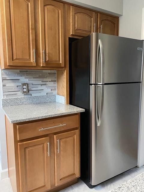 Honey Maple kitchen cabinets and stainless steel appliances.