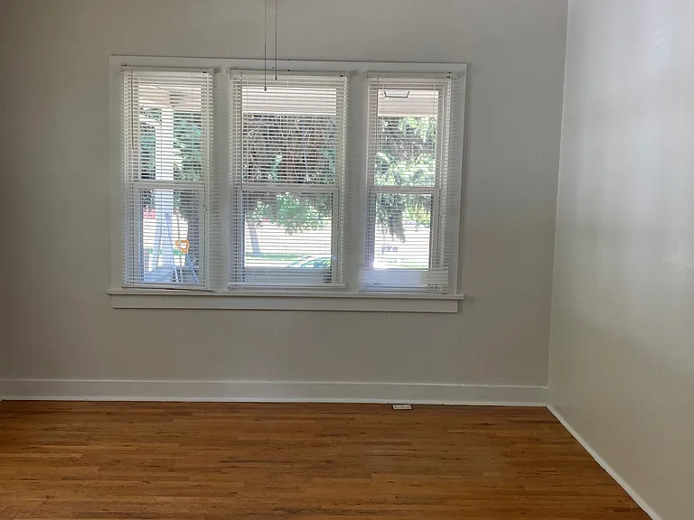 Large main bedroom has wood floors and lots of natural light.